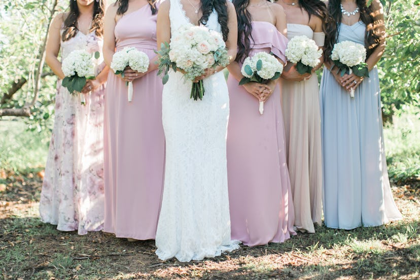 bride and bridesmaids holding wedding bouquets, pastel bridesmaids dresses, detail shot, copy space