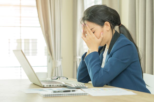 Portrait of tired young business woman with laptop computer