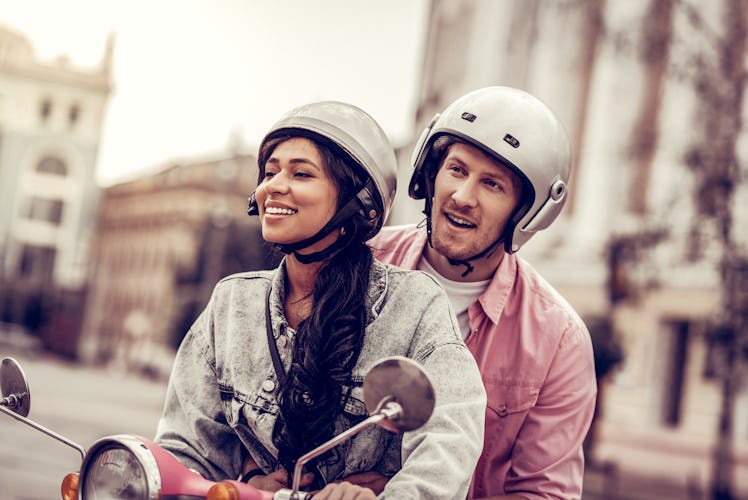 Having fun. Delighted happy couple having fun while riding a motorcycle together