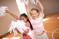 Girls laughing. Beautiful little girls wearing sport clothing laughing while practicing cheerleading