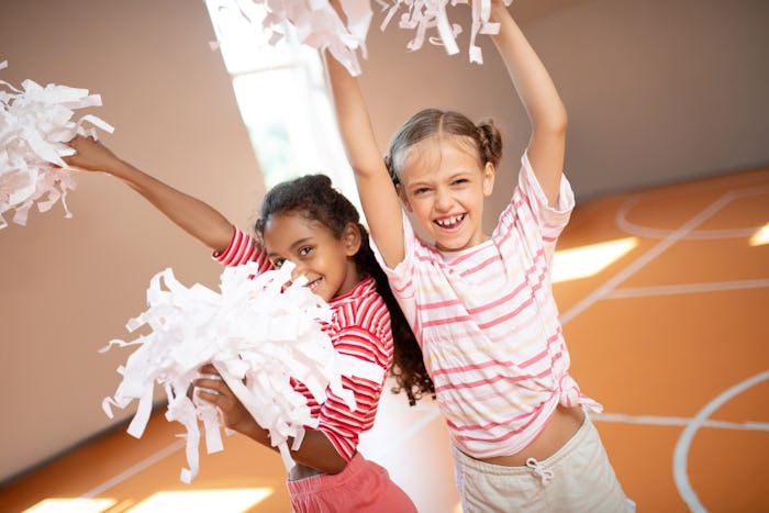 Girls laughing. Beautiful little girls wearing sport clothing laughing while practicing cheerleading