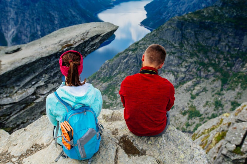 Back of couple relaxing against amazing nature view over view on Trolltunga. Location: Scandinavian ...
