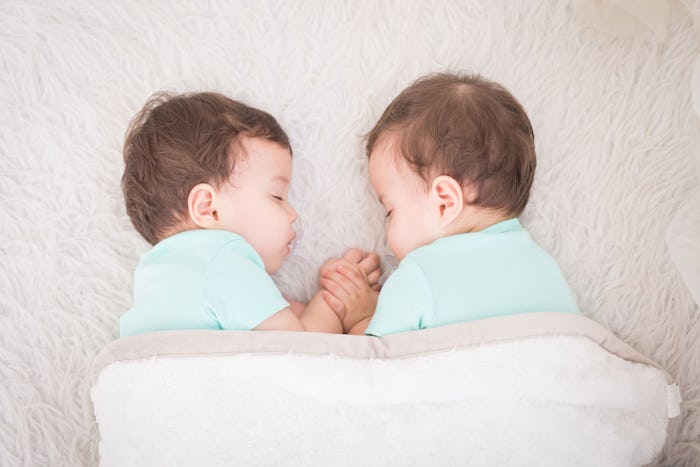 Newborn beautiful baby twins sleeping with pacifier. Closeup portrait, caucasian child