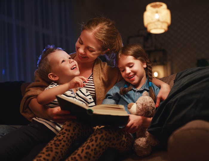 evening family reading. mother reads children a book before going to bed
