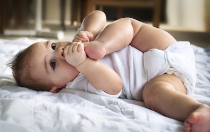 Baby lying down with foot in mouth