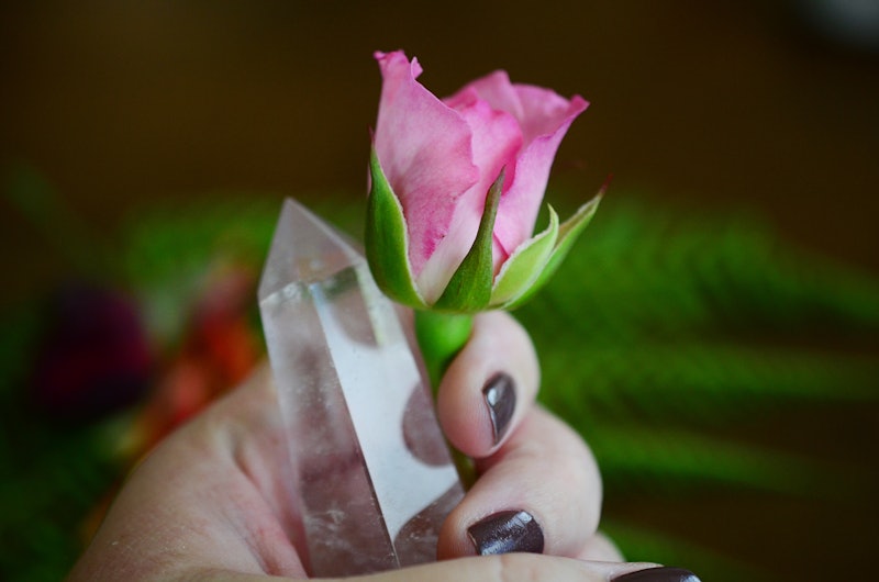Beautiful Clear Quartz tower, and fresh pink rose flowers. Bright Quartz crystal, healing crystal be...