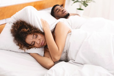 Snoring man is annoying. Young african-american woman suffering from her noisy sleeping boyfriend