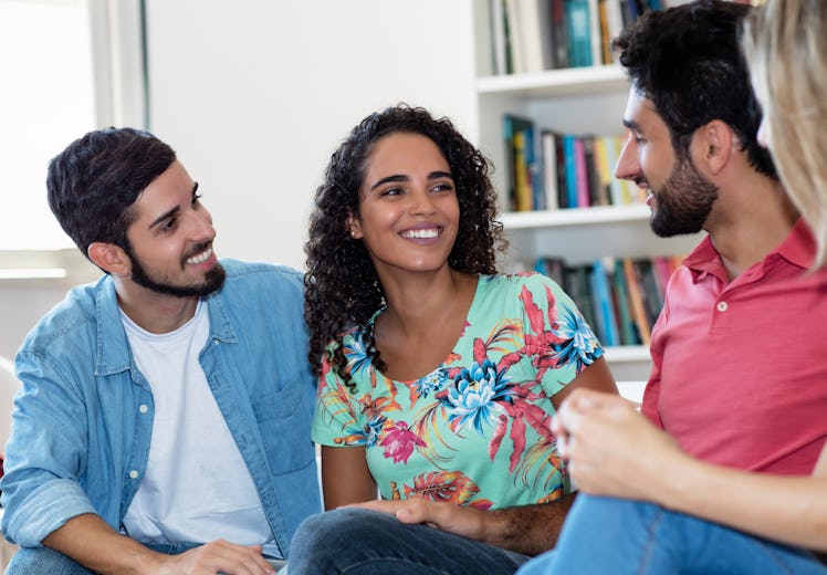 Beautiful latin american woman talking with friends indoors at home