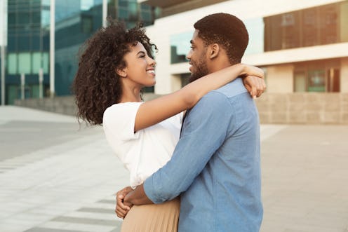 Couple date. Romantic african-american pair hugging and walking in city