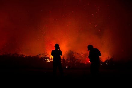 Residents inspect a fire in Palangkaraya, Central Kalimantan, Indonesia, 23 September 2019 (issued 2...