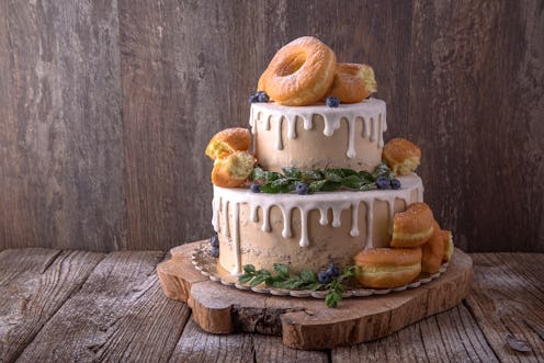 Wedding cake decorated with donuts and wild berries. Fashionable luxury stylish cake