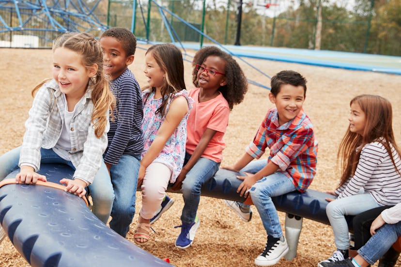 Kids sitting on a spinning carousel in their schoolyard