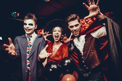 Young People in Costumes Celebrating Halloween. Group of Young Happy Friends Wearing Halloween Costu...