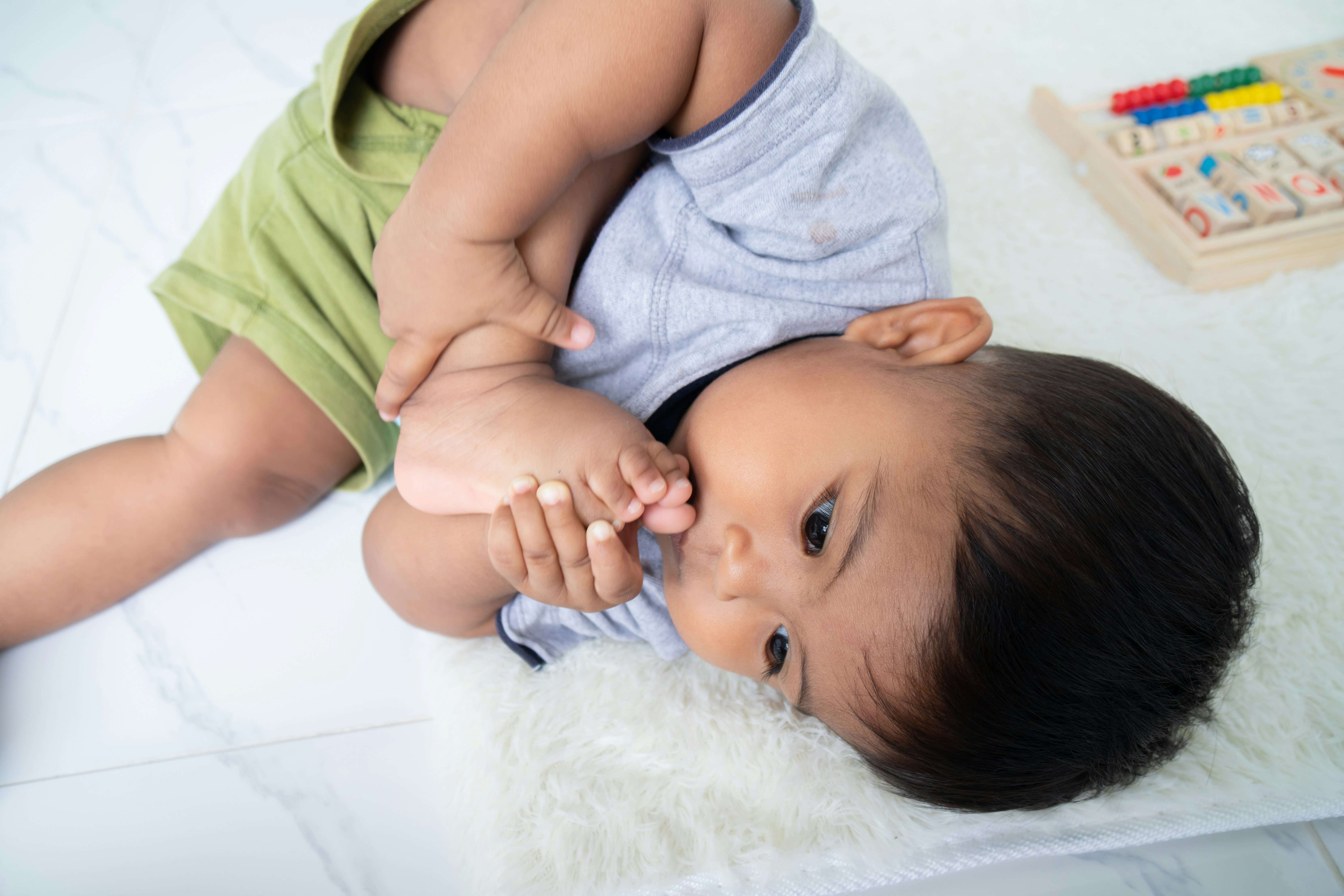 baby putting hand in mouth 3 months