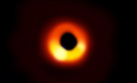 A black hole surrounded by orange and yellow lights