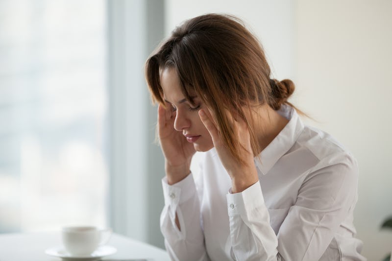 Tired exhausted businesswoman having strong headache migraine at work touching massaging temples, st...