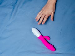 woman reaches for the bedside table for sex toy.