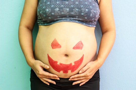 Halloween painted on belly of pregnant woman