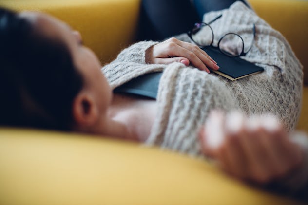 Woman sleeping on the couch with a book