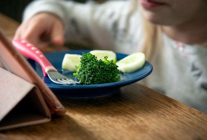 Child little girl eats broccoli and cucumber. Concept, healthy eating.