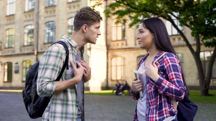Emotional male student talking with ex-girlfriend near university, relationship