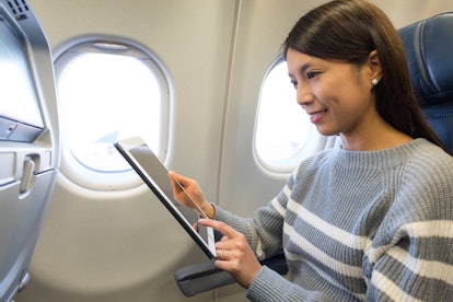 Woman use of tablet inside airplane