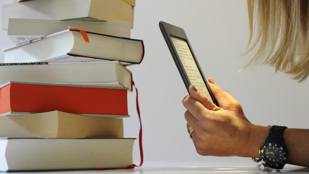 Young woman reading an e-book on a Kindle