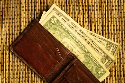Dollars in a wallet on a wooden bamboo background. money on the table. finance background