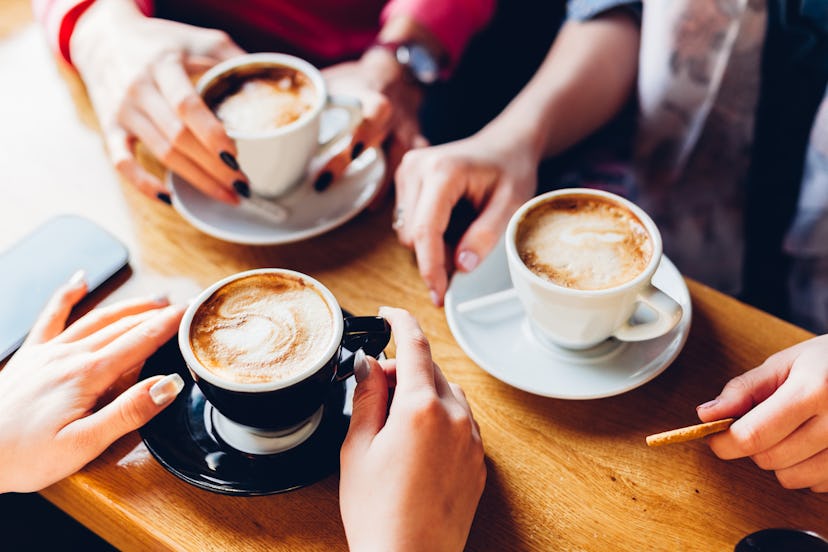 Closeup of hands with coffee cups in a cafe