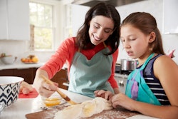 Jewish mother and daughter glazing dough for challah bread in a round up of Rosh Hashanah quotes