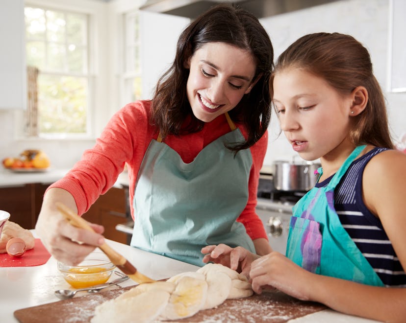Jewish mother and daughter glazing dough for challah bread in a round up of Rosh Hashanah quotes