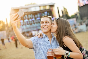 Couple taking selfie and having fun at music festival