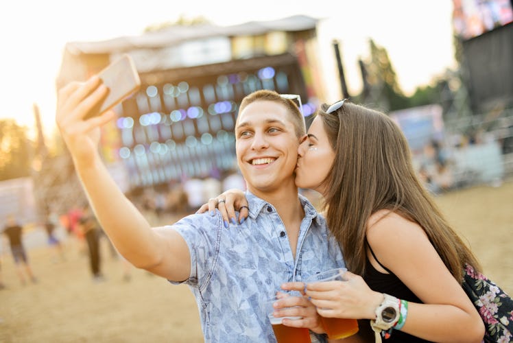 Couple taking selfie and having fun at music festival