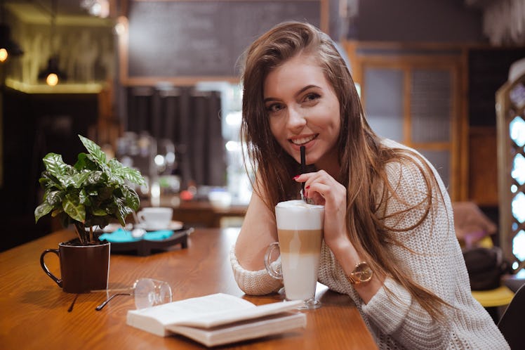 Preaty girl with big latte and book in coffee house