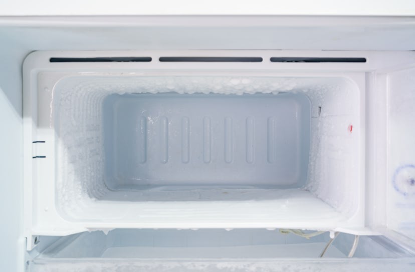 empty freezer of a refrigerator - Ice buildup on the inside of a freezer walls. 