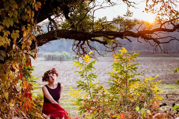 Sensual woman under the autumnal tree on sunset