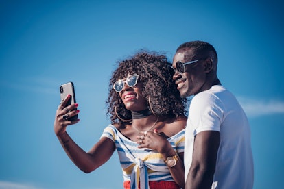 Couple of Africans taking a selfie with a mobile phone.