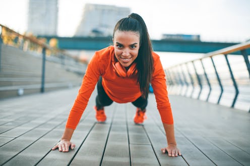 Young woman exercises on the promenade after running in the morning