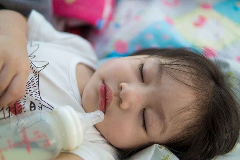 Adorable Asian baby sleeping and drinking milk.