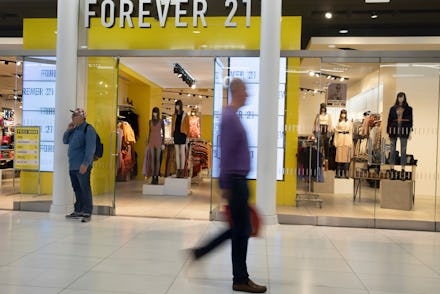 People walk in front of a Forever 21 clothing store, in New York. Low-price fashion chain Forever 21...