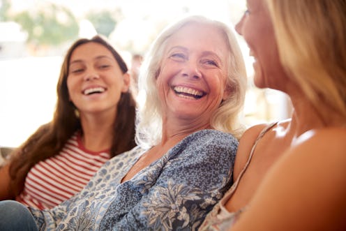 Mother With Adult Daughter And Teenage Granddaughter Relaxing On Sofa And Talking At Home