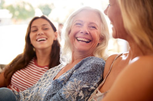 Mother With Adult Daughter And Teenage Granddaughter Relaxing On Sofa And Talking At Home