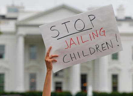 Donald Trump, Kirstjen Nielsen, Mike Pence. A demonstrator hold up a sign during a rally opposed to ...