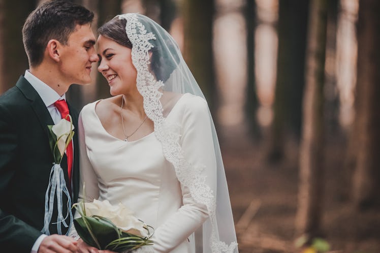 young family, the wedding, the newlyweds. Bride and groom walk around the trees in an autumn forest