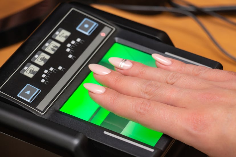 The process of scanning fingerprints during the check at border crossing. Female hand puts fingers t...