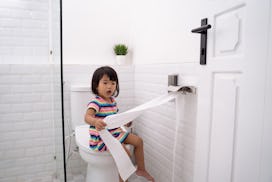 toddler pulling out toilet paper while playing around in the bathroom