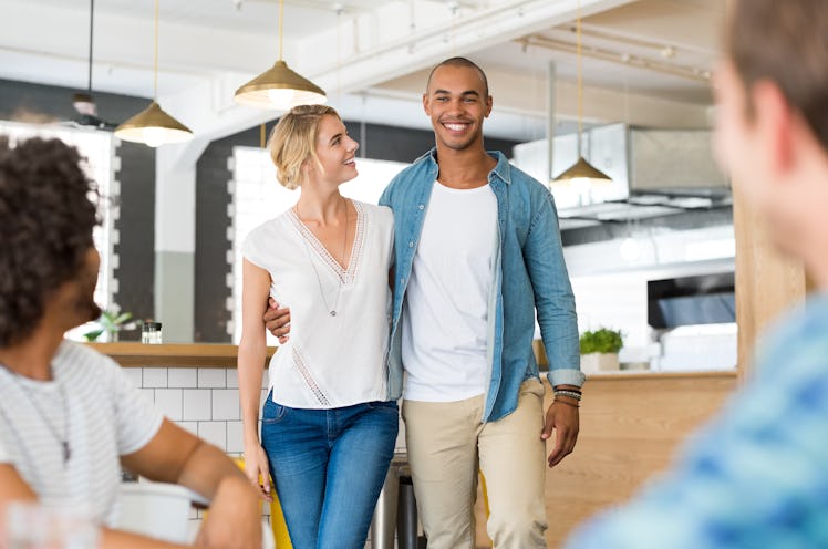 Happy cheerful african man introducing his beautiful girlfriend to his friends. Happy friends meetin...