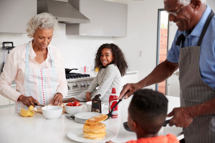Grandparents In Kitchen With Grandchildren Making Pancakes Together