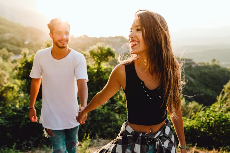Portrait of beautiful young couple enjoying nature at mountain peak.