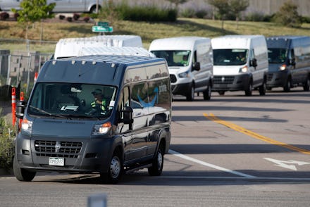 R m. Graph, vans queue up to leave an Amazon delivery center in suburban Englewood, Colo